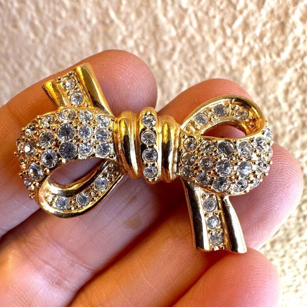 Roman gold tone rhinestone bow brooch